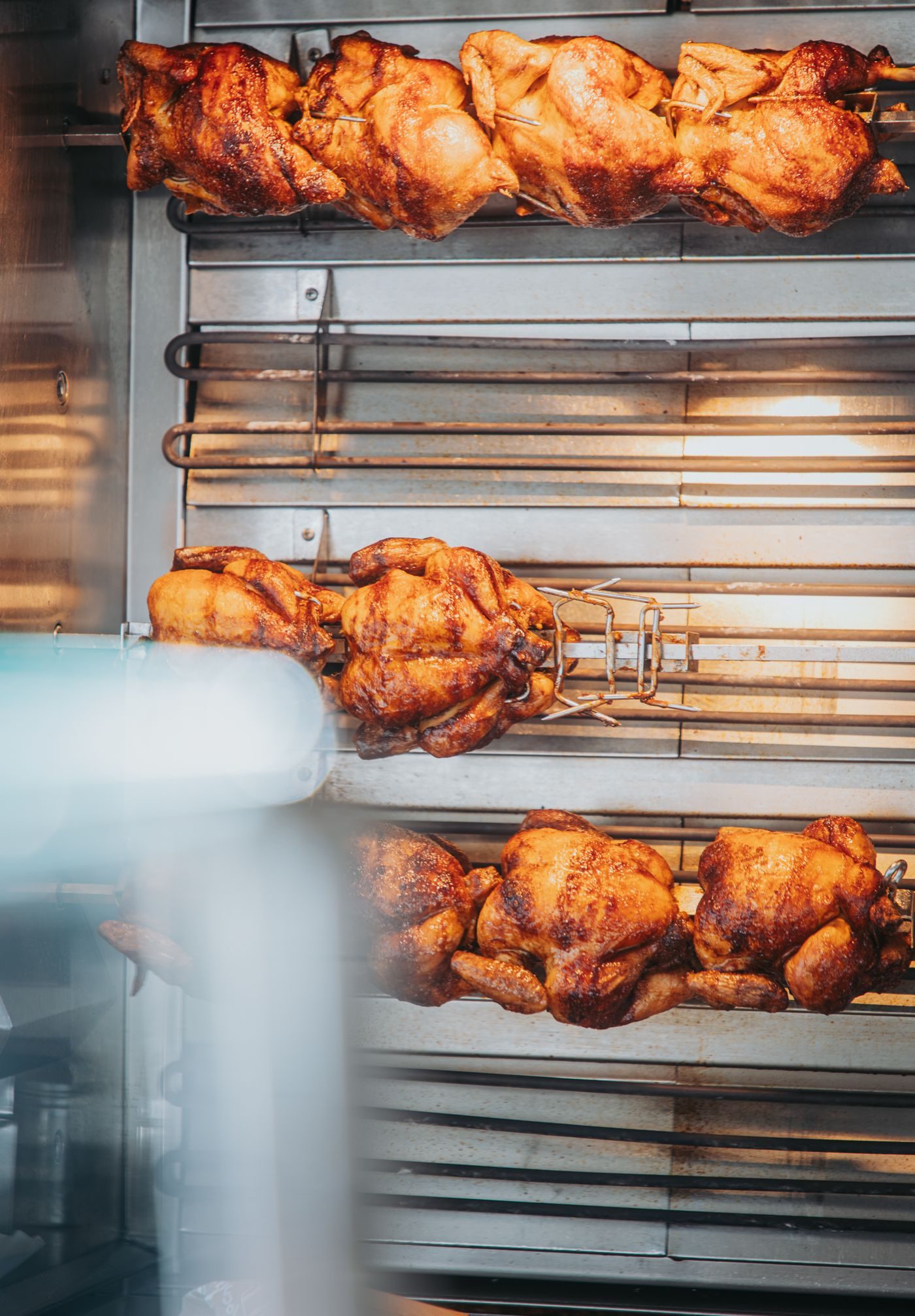 Des poulets dorés tournent sur les broches de la rôtissoire.